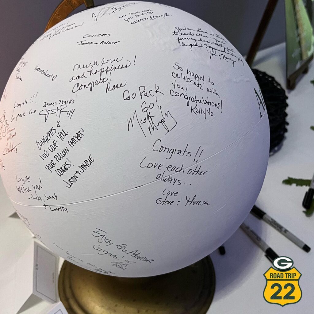 Packers president and CEO writes Go Pack Go on white sphere that is a wedding guest list.
